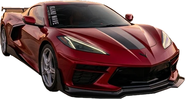 Red Chevrolet Corvette sports car with a black center stripe, viewed from the front-left on a dirt lot.